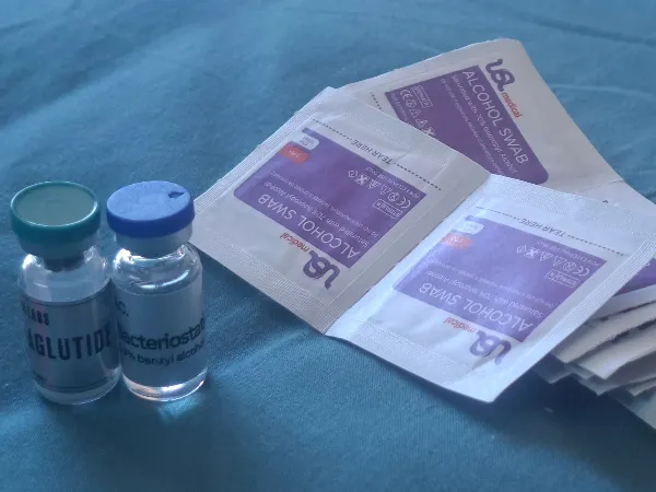 Customer photo: Two vials and alcohol swabs, as received
